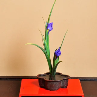 床の間に飾られた紫の花を用いた生け花作品