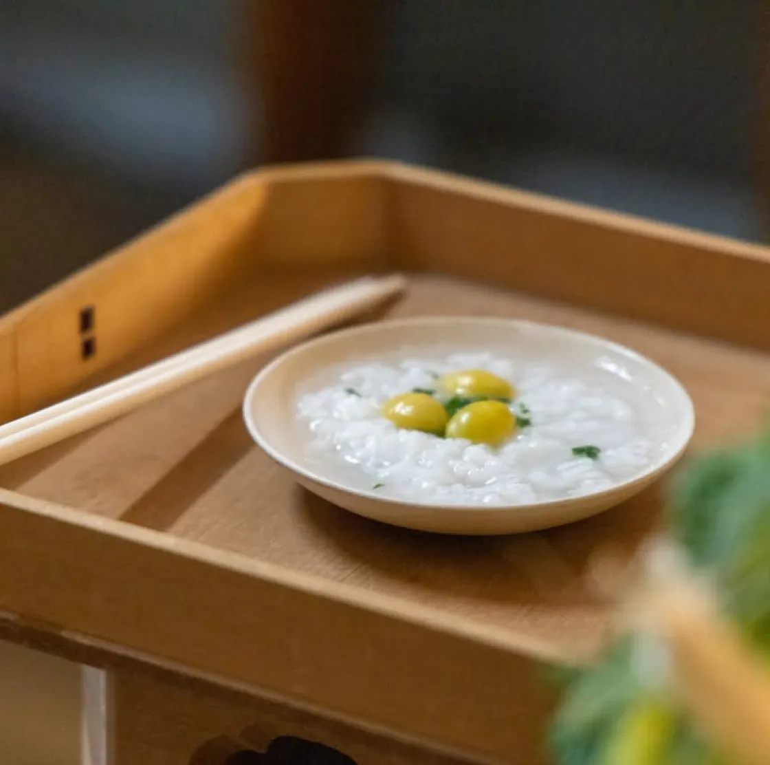 木製の盆の上に置かれた白いお粥の器。銀杏粥神事の様子