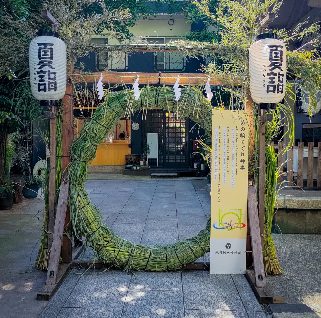 夏越の祓で設置された大きな茅の輪が立つ神社の参道入口。夏越大祓式の様子