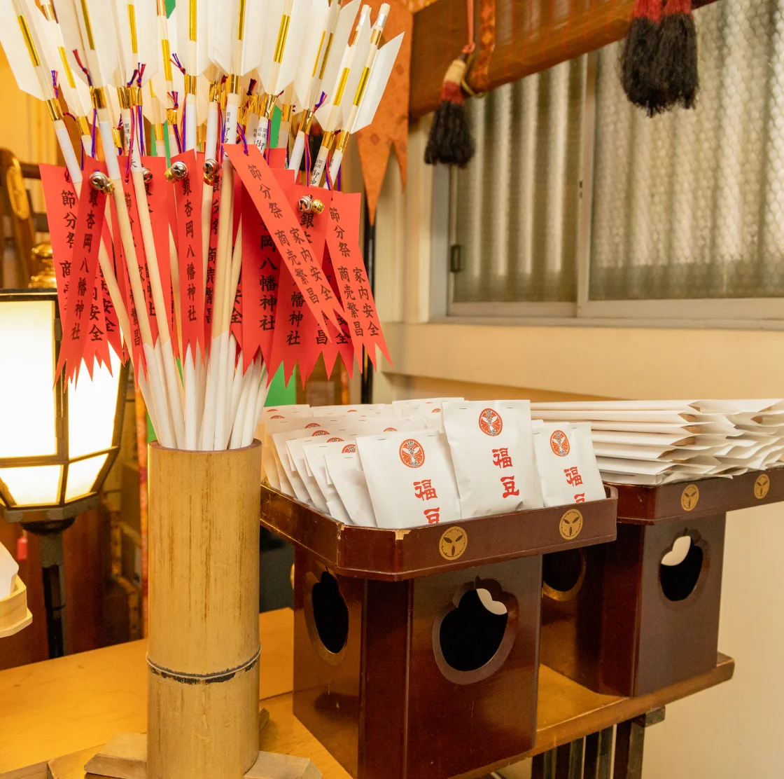 神社の授与所に並ぶ破魔矢と節分用の福豆。節分祭の様子